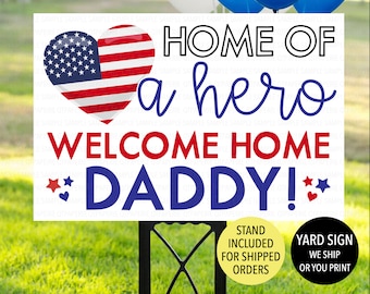 May include: A white yard sign with the text "HOME OF a hero WELCOME HOME DADDY!" in red and blue. A heart-shaped graphic with the American flag design is on the left. The sign is on a black stand, with balloons in the background.