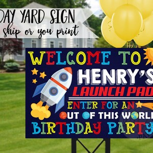 May include: A blue and white yard sign with a rocket ship, stars, and planets. The sign says "Welcome to Henry's Launch Pad! Enter for an out of this world birthday party!"