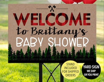 May include: A brown and white welcome sign with red and black plaid text that reads "Welcome to Brittany's Baby Shower". The sign has a green forest silhouette at the bottom and a stand included for shipped orders.