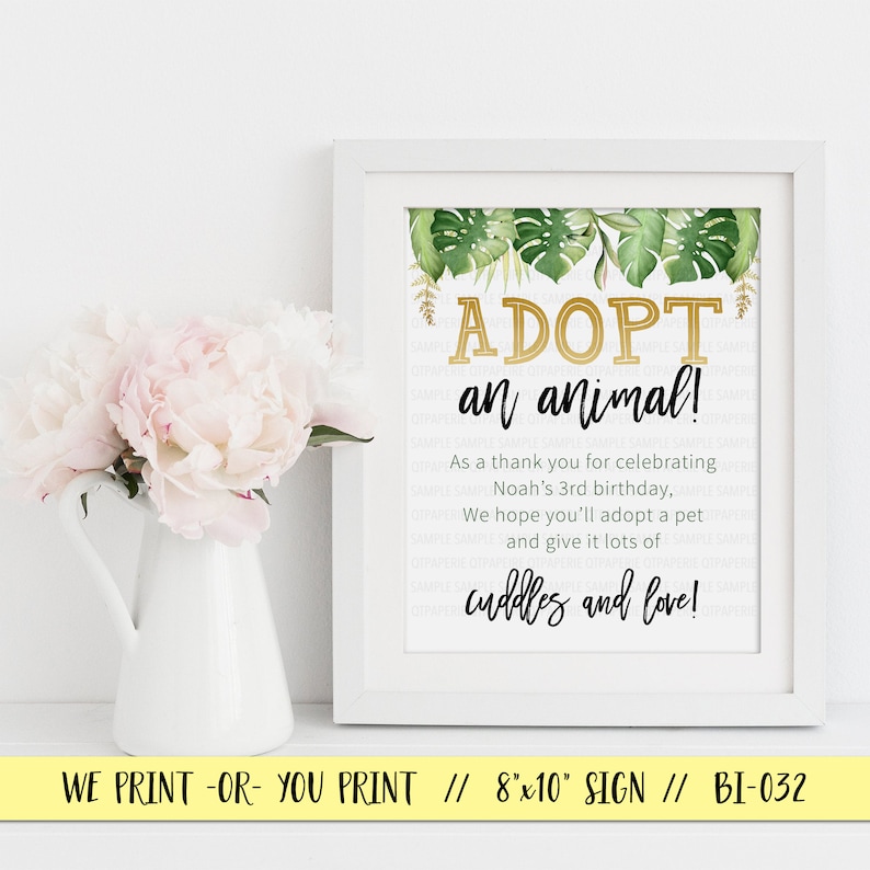 May include: A white framed sign with a green and gold tropical theme. The sign says "Adopt an animal!" and includes the text "As a thank you for celebrating Noah's 3rd birthday, We hope you'll adopt a pet and give it lots of cuddles and love!"  The sign is an 8x10 inch print.