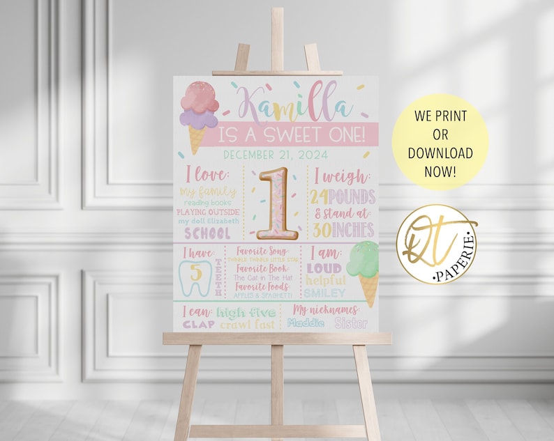 May include: A pink and white printable first birthday sign with an ice cream cone design. The sign says "Kamilla is a sweet one!" and includes details like her weight, height, favorite foods, and activities.