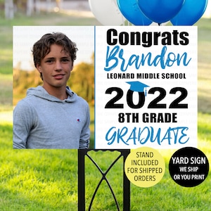K&ouml;nnte beinhalten: Ein wei&szlig;es Schild f&uuml;r den Garten mit einer blauen Abschluss-Kappe, schwarzem Text, der "Congrats Brandon Leonard Middle School 2022 8th Grade Graduate" lautet, und einem Foto eines jungen Mannes. Das Schild enth&auml;lt auch den Text "Stand Included for Shipped Orders" und "Yard Sign We Ship or You Print".