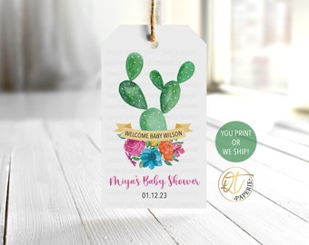 May include: A white tag with a green cactus illustration and floral accents. The text "Welcome Baby Wilson" is on a yellow banner. The tag also says "Miya's Baby Shower 01.12.23".
