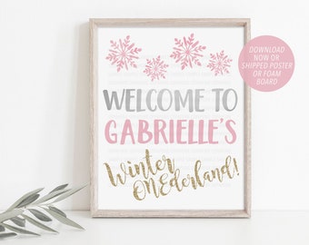 May include: A printable sign with a pink and grey welcome to Gabrielle's Winter Wonderland! text. The sign is decorated with pink snowflakes.