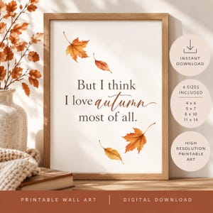 May include: A framed wall art print featuring the text But I think I love autumn most of all in dark brown lettering. The design includes four watercolour maple leaves in shades of orange and yellow scattered around the central quote.