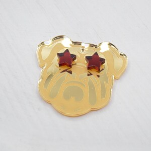 Pu&ograve; includere: Testa di bulldog in specchio dorato con occhi a forma di stella rossa.