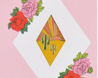 Könnte beinhalten: Eine gelbe, rautenförmige Anstecknadel mit einem Sonnenuntergangs- und Kaktus-Motiv. Die Nadel ist von rosa und roten Rosen umgeben. Der Text "Rosie Wonders Lapel Pin" ist auf der Karte gedruckt.