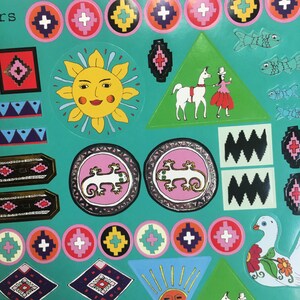 Pu&ograve; includere: Una collezione colorata di adesivi con vari disegni, tra cui un sole, una lucertola, un lama, un uccello e motivi geometrici. Gli adesivi sono su uno sfondo turchese.