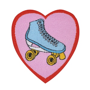 May include: A pink heart-shaped patch with a blue roller skate with yellow wheels. The patch is embroidered with red stitching around the edges.
