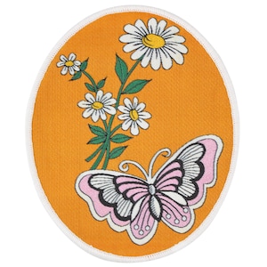 May include: An orange oval-shaped patch with a pink butterfly and white daisies embroidered on it.