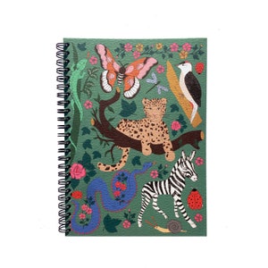 Può includere: Un quaderno a spirale verde con una scena di giungla colorata che presenta un leopardo, una zebra, una farfalla, un serpente e un uccello. La copertina è decorata con fiori e foglie.