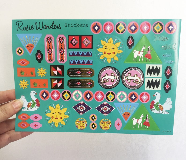 Pu&ograve; includere: Un foglio di adesivi colorati su sfondo turchese. Gli adesivi presentano vari disegni, tra cui soli, uccelli, motivi geometrici e lama. Il testo "Rosie Wonders Stickers" &egrave; stampato nella parte superiore del foglio.
