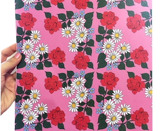 May include: Pink wrapping paper with a repeating pattern of red roses, white daisies, and blue forget-me-nots.