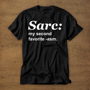 May include: Black t-shirt with white text that reads "Sarc: my second favourite -asm."