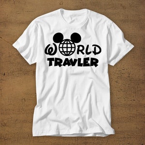 May include: White t-shirt with a black graphic of Mickey Mouse ears, a globe, and the text "WORLD TRAVLER".