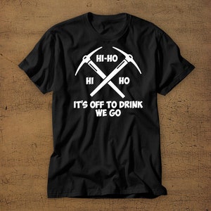 Puede incluir: Camiseta negra con un gr&aacute;fico blanco de dos picos cruzados y el texto "Hi-Ho Hi Ho It's Off To Drink We Go".