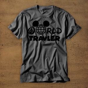 May include: A gray t-shirt with a black graphic of Mickey Mouse ears with a globe inside and the text "WORLD TRAVELER" underneath.
