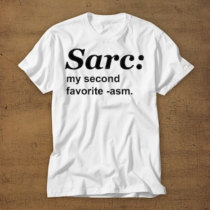 May include: White t-shirt with black text that reads "Sarc: my second favourite -asm."