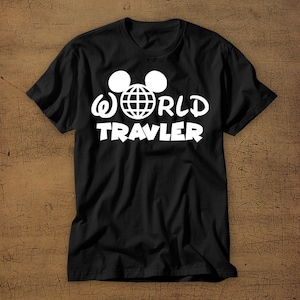 May include: Black t-shirt with a white graphic of Mickey Mouse ears with a globe inside and the text "WORLD TRAVLER"