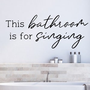 May include: A white bathroom with a bathtub and a wall decal that reads "This bathroom is for singing."