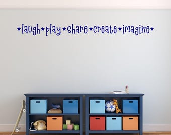 Puede incluir: Dos estantes azules con varios juguetes y contenedores de almacenamiento. Los estantes están contra una pared azul claro con las palabras "laugh * play * share * create * imagine *" en letras azules.