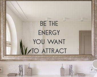 May include: A bathroom mirror with a motivational quote: "Be the energy you want to attract".