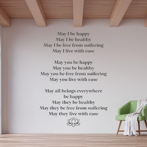 May include: A white wall with a gray text quote about happiness, health, and freedom from suffering. The quote is centered on the wall and includes a stylized lotus flower at the bottom. A green armchair with a white throw blanket is in the foreground.