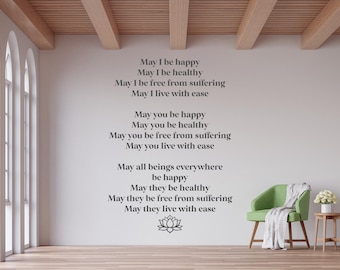 May include: A white wall with a gray text quote about happiness, health, and freedom from suffering. The quote is centered on the wall and includes a stylized lotus flower at the bottom. A green armchair with a white throw blanket is in the foreground.