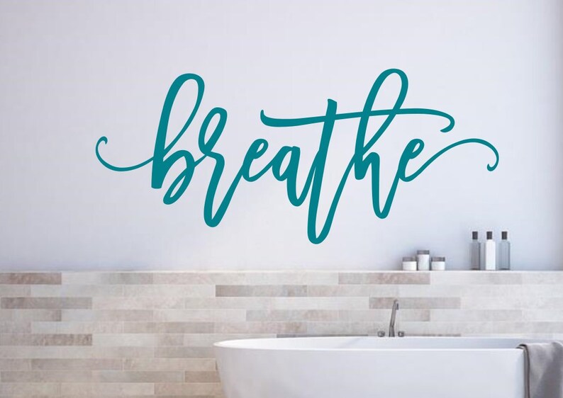 Puede incluir: Un vinilo decorativo de pared "breathe" en color turquesa, escrito en cursiva. La palabra se muestra en una pared blanca, sobre un ba&ntilde;o con una ba&ntilde;era blanca y objetos decorativos.