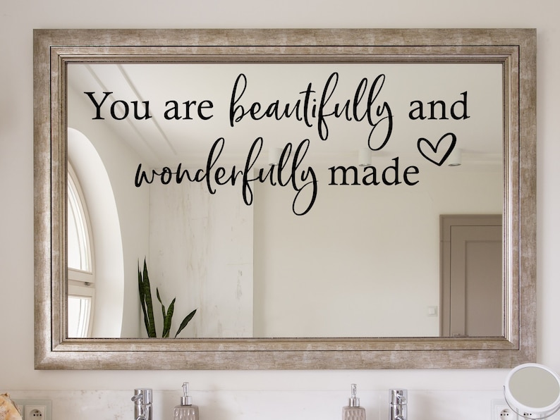Op de afbeelding: Een zilveren spiegel met de tekst "You are beautifully and wonderfully made" in zwarte letters met een klein hartje.