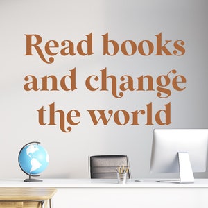 May include: A white desk with a globe, a computer, and a chair. The wall behind the desk has the text "Read books and change the world" written in brown.