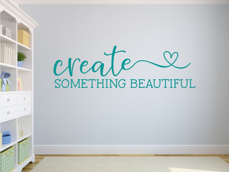 Pu&ograve; includere: Adesivo murale turchese con il testo "create something beautiful" e un piccolo simbolo di cuore.