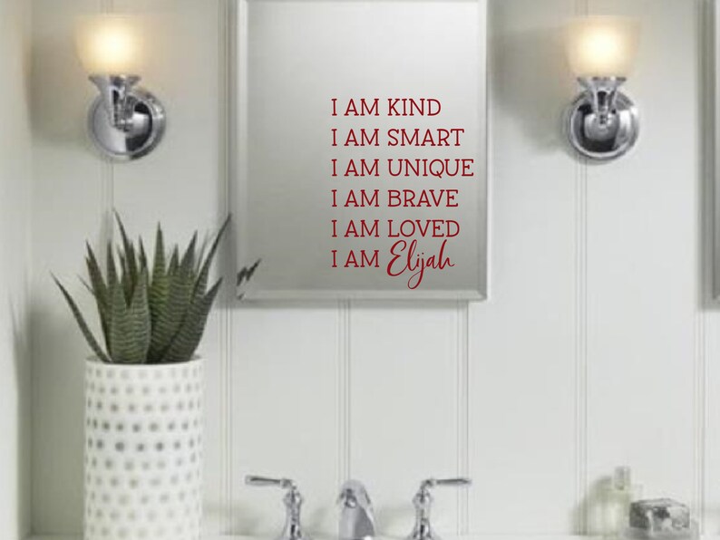 May include: A white bathroom mirror with a red vinyl decal that reads "I am kind, I am smart, I am unique, I am brave, I am loved, I am Elijah".