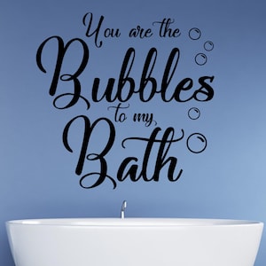 Puede incluir: Una calcomanía de pared para baño en blanco y negro con el texto "You are the bubbles to my bath" y varios círculos pequeños que representan burbujas.
