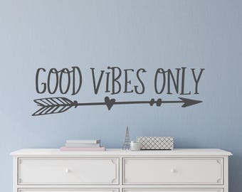May include: A white dresser with two drawers and a black arrow with the text "GOOD VIBES ONLY" above it.