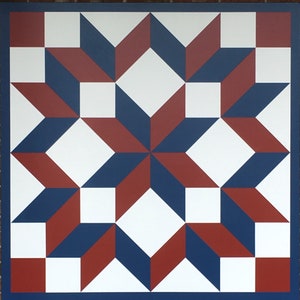 May include: A red, white, and blue quilt block with a star pattern. The quilt block is made of squares and triangles.