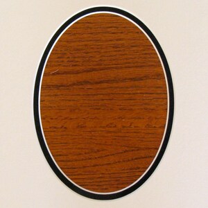 May include: A wooden oval plaque with a black and white border. The plaque is blank and ready to be personalized.