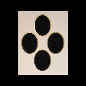 May include: A white picture frame with four oval openings, each with a gold border. The openings are empty.