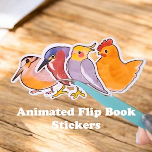 Puede incluir: Cuatro pegatinas de pájaros coloridos con un pájaro azul, rojo y amarillo, un cacatúa gris y una gallina amarilla. Las pegatinas están dispuestas en una fila y se sostienen con unas pinzas. El texto "Animated Flip Book Stickers" es visible debajo de las pegatinas.