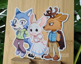 May include: Three cartoon animal stickers featuring a blue wolf, a white rabbit, and a brown deer. The wolf is wearing a green hoodie and blue jeans. The rabbit is wearing a white dress with blue trim. The deer is wearing a blue shirt and brown pants.