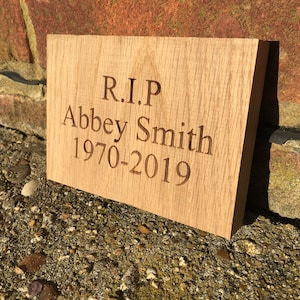 May include: A wooden plaque with the text "R.I.P. Abbey Smith 1970-2019" engraved on it.