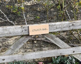May include: A wooden sign with the text "church lee" attached to a wooden fence.
