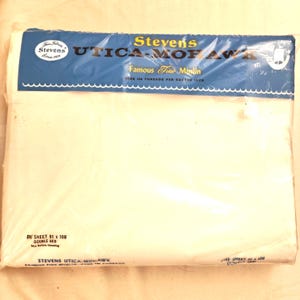 May include: A white Stevens Utica-Mohawk double bed sheet in original plastic packaging. The blue label features the text Stevens Utica-Mohawk Famous Fine Muslin Over 156 Threads Per Square Inch and One Sheet 81 x 108 Double Bed Size Before Hemming.