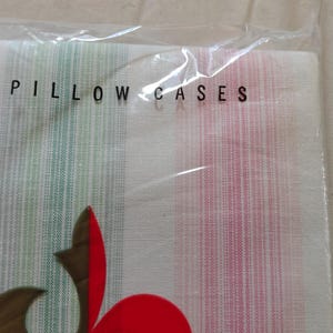 May include: Two pillow cases in a clear plastic package. The pillow cases have vertical stripes in yellow, green, and pink. The text "TWO PILLOW CASES" is printed in black on the plastic.