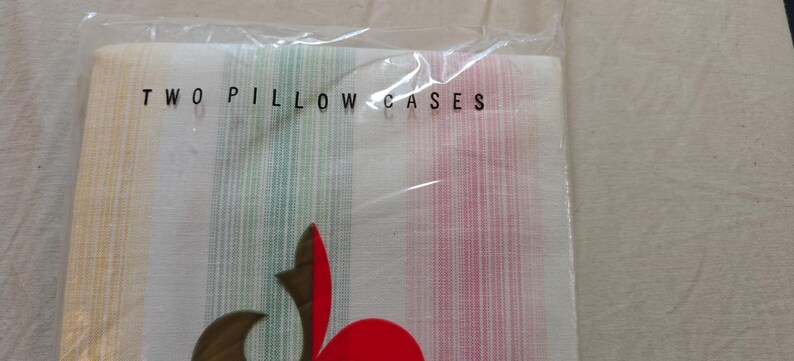 May include: Two pillow cases in a clear plastic package. The pillow cases have vertical stripes in yellow, green, and pink. The text "TWO PILLOW CASES" is printed in black on the plastic.