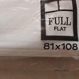 K&ouml;nnte beinhalten: Ein wei&szlig;es, flaches Spannbettlaken, verpackt in durchsichtigem Kunststoff. Die Verpackung tr&auml;gt den Text "FULL FLAT" in einem schwarzen Rechteck mit den Ma&szlig;en "206x274cm" darunter.