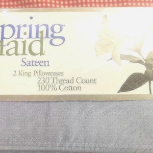 May include: A package of Spring Maid Sateen bed sheets. The packaging is white with the brand name in blue and green. The package includes two king pillowcases, a 230 thread count, and is 100% cotton. A floral design is on the packaging, and the sheets are a light blue color.
