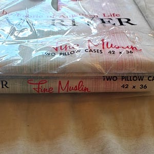 May include: A package of Dan River Fine Muslin pillowcases. The package is clear plastic, and the pillowcases are folded inside. The text "TWO PILLOW CASES 42 x 36" is printed on the package. The pillowcases measure 42 inches by 36 inches.