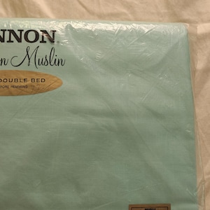 May include: A package of Cannon Fashion Muslin in a light blue color. The packaging includes text that reads "Cannon Fashion Muslin" and "81x99 Double Bed". The package is sealed in clear plastic.