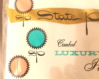 May include: A white package with the text State P, Combed, and LUXURY. The design features three stylized flower icons with jagged edges in peach and teal colors, each accompanied by the letters sp in a cursive script font.